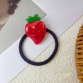 Dettaglio di un elastico per capelli a fragola con strass scintillanti e foglie verdi - Fragola