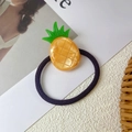 Dettaglio dell'elastico per capelli con ciondolo a forma di ananas giallo in resina lucida - Ananas