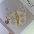 Detailansicht der Schmetterling Haarklammer mit hellblauen Blumen und glänzenden Kristallen - Beige