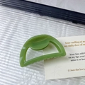 Detalle de una pinza para el pelo semicircular hueca verde hierba con acabado brillante - Verde