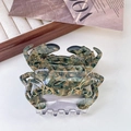 Detail of crab hair claw clip with grey-green marble texture and gold trim finish - Green