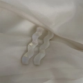 Detalle macro de pinzas para el cabello nacaradas onduladas sobre fondo de tela blanca - 3# Perla de Sirena