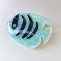 Detail of fish-shaped acetate hair claw with mint green marble texture and black stripes - Blue