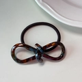 Detailopname van een amberkleurige cellulose-acetaat haarelastiek met een oneindige knoop - Blauw Bruin