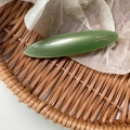 Detail view of the deep olive green oval acetate barrette with golden French lettering - Green