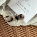 Detailed macro view of tortoise shell acetate bow hair clip with gold logo on cream paper - Candy Bow Knot / Light Tortoiseshell