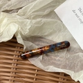 Close-up of tortoise shell acetate hair clip with golden Barrette La France lettering - Bobby Pin / Blue Brown