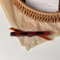 Détail d'une barrette fine à motif écaille de tortue sur un fond beige texturé - Écaille de tortue 3