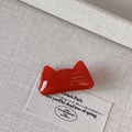 Gros plan d'une barrette chat rouge avec inscription dorée sur un fond beige texturé - Forme d'Oreille de Chat (5602927540089)
