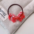 Close-up of red marble pattern resin bow on elastic hair tie with beige quilted background - 6# Clear Acetate Bow - Transparent Red