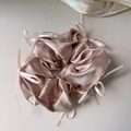 Dettaglio dell'elastico in raso rosa champagne con piccoli fiocchi in nastro e seta - Albicocca