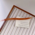 Detailed shot of amber acetate hair pin with France Handmade text on velvet tray - Iridescent Light Coffee