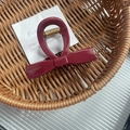 Elegant bow-shaped hair claw clip in deep burgundy resin finish with gold metal spring - Red