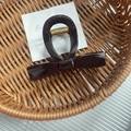 Elegant dark coffee bow hair claw clip made of high-gloss acrylic in a woven basket - Coffee