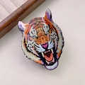 Vista macro detallada de una pinza para el pelo con cabeza de leopardo y acabado esmaltado - Tigre