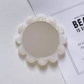 Primer plano de un mini espejo de maquillaje de acetato blanco perlado con forma floral - Sirena Irisada