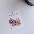 Detail view of a Scottie dog hair clip made from colorful marbled acetate with rhinestones - Rainbow