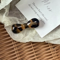 Classic tortoise shell acetate bow hair clip with gold logo on white tissue background - Candy Bow Knot / Tortoiseshell