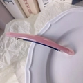Barrette en acétate rose et bleu marine avec logo doré sur fond blanc élégant - Rose