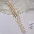 Dettaglio di pettine in acetato perlato a denti larghi con elegante trama marmorea - Beige