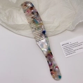 Dettaglio del pettine in acetato colorato con trama marmorea e design del manico ergonomico - 4# Multicolore