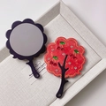 Close-up of floral acetate handheld mirror with red cherry rhinestones and branch handle - Red