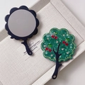 Close-up of elegant cherry tree pattern on green marble texture hand mirror with rhinestones - Green