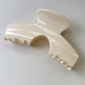 Detalle de la textura blanco crema y los dientes de agarre de esta gran pinza para el cabello - Blanco Leche