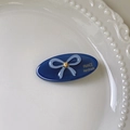Détail de la barrette ovale bleue avec nœud, strass et logo France Handmade gravé - Bleu