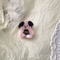 Close-up of pink dog hair claw with black ears and yellow M logo on a textured background - Pink