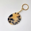 Detail of a mini acetate comb keychain with tortoiseshell texture and gold ring - Light Leopard Print (Gold Keychain)