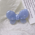Dettaglio del fermaglio a farfalla in acetato blu con cristalli e logo dorato - Blu