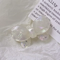 Dettaglio macro della molletta a farfalla in acetato bianco con strass viola scintillanti - bianco sirena