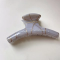 Detail of a purple translucent shark hair claw with gold vein pattern and lace texture - Arc Style / Gray