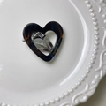 Detail of tortoiseshell heart hair clip showing silver metal spring and golden logo - Hollow Heart / Blue Brown