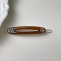 Detalle de pinza para el pelo ovalada marrón con pedrería y grabado en color oro - Marrón