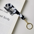 Macro shot of marble acetate comb keychain on an open book showcasing fine texture - Gold Clasp / Black & White