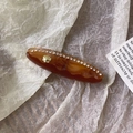 Detalle de una pinza de acetato ámbar con pedrería y un toque de concha dorada - Pinza de Pelo Café