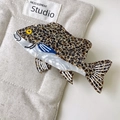 Makro-Detail einer fischförmigen Acetat-Haarklammer mit Leopardenflecken und weißen Akzenten - Kaffee Gefleckt Tiger Greifer