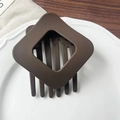 Dettaglio della molletta per capelli quadrata marrone caffè con texture opaca su piatto - Marrone