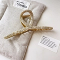 Close-up of cream marble acetate hair claw clip on linen pouch with golden metal spring - 6# Beige Apricot Style