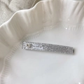 Macro shot of silver glitter hair clip with heart rhinestone and white text detail - 7cm / Silver