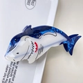 Detailed view of ocean-inspired Great White Shark hair claw made of blue marble acetate - Blue