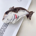 Close-up of shark-shaped hair claw with brown marble and cream acetate patterns - Brown