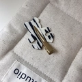 Dettaglio ravvicinato di una clip per capelli a orso in acetato con motivo zebrato e oro - Nero & Bianco