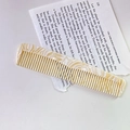 Detailed macro view of an acetate hair comb with elegant marble texture on vintage paper - Beige