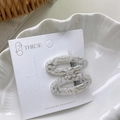 Elegant pair of oval acetate hair clips with white marble texture on a display card - Oval Hollow Style / Spotted White