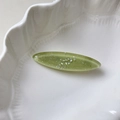 Detalle macro de pinza para el pelo ovalada de resina verde con purpurina brillante - Verde