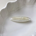 Detail of oval resin hair clip with silver glitter and flakes on white ceramic - Clear White