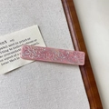 Dettaglio macro di fermaglio per capelli rosa con rilievo loto argento e strass - Rosa